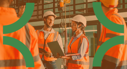 Man and woman in PPE and orange vests presenting as part of a safety training program on a factory floor